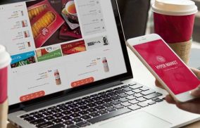 A laptop displaying an online store and a person ordering from home